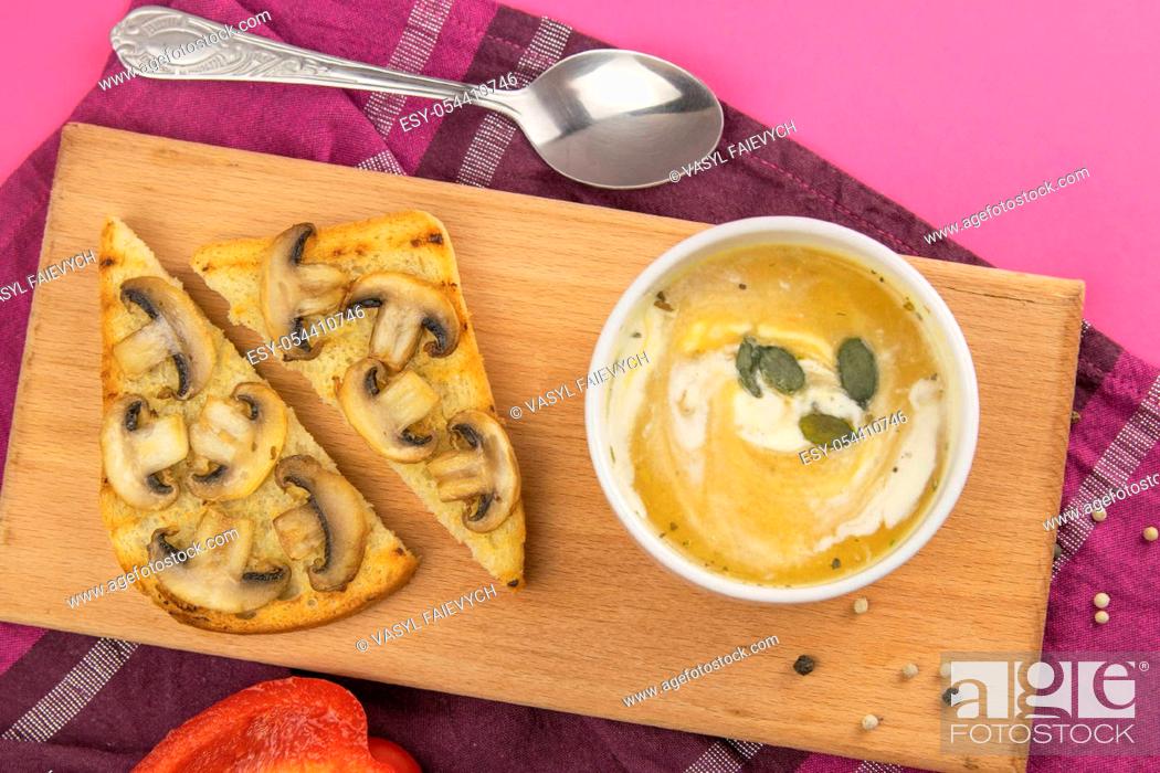 Stock Photo: Pea soup with croutons stands on a green towel, next to there are tomatoes, toasts of pumpkin seeds, everything stands on the yellow table.