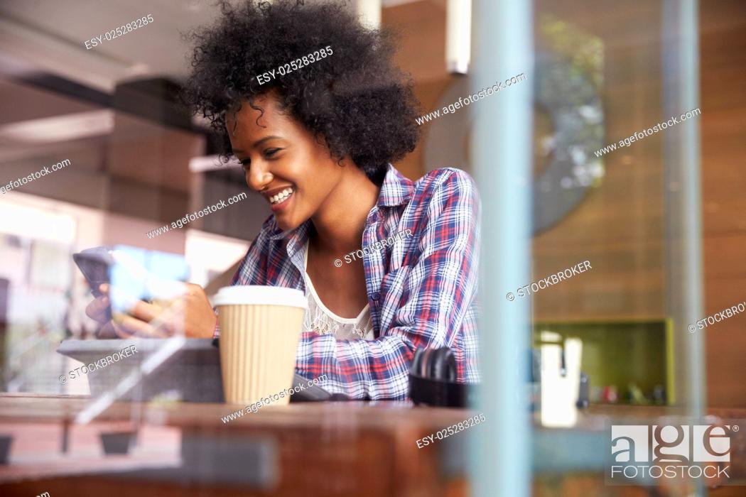 Stock Photo: Businesswoman On Phone Using Digital Tablet In Coffee Shop.