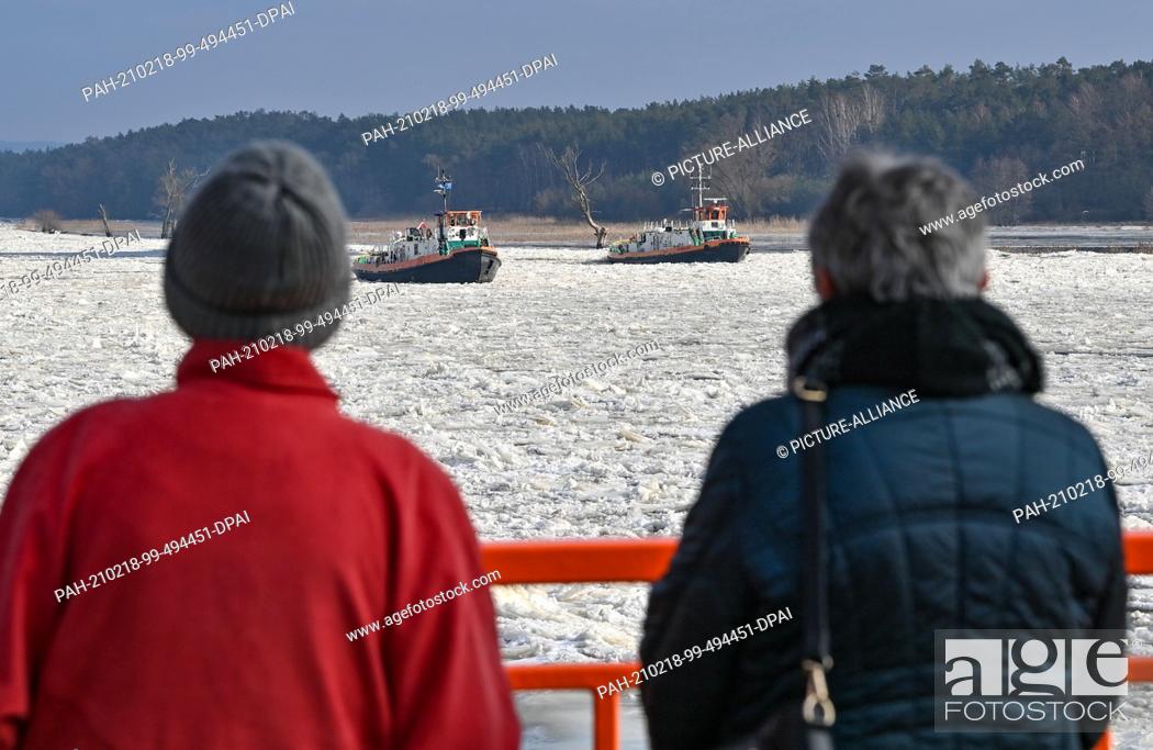 Stock Photo: 18 February 2021, Brandenburg, Schwedt: Two Polish icebreakers are sailing on the German-Polish border river Oder. Drift ice is increasing the danger of.