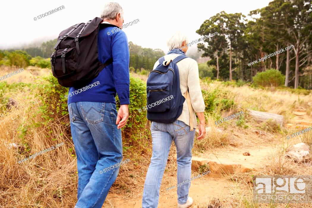 Stock Photo: Senior couple walking together in a forest, close-up back view.