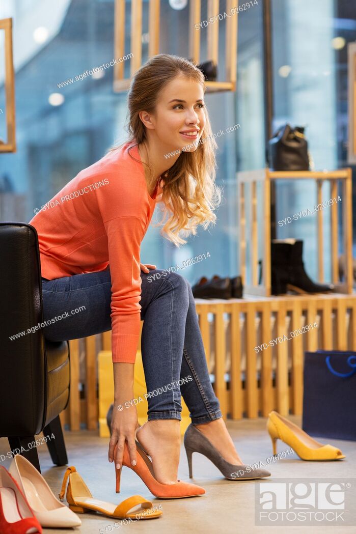 Photo de stock: young woman trying high heeled shoes at store.
