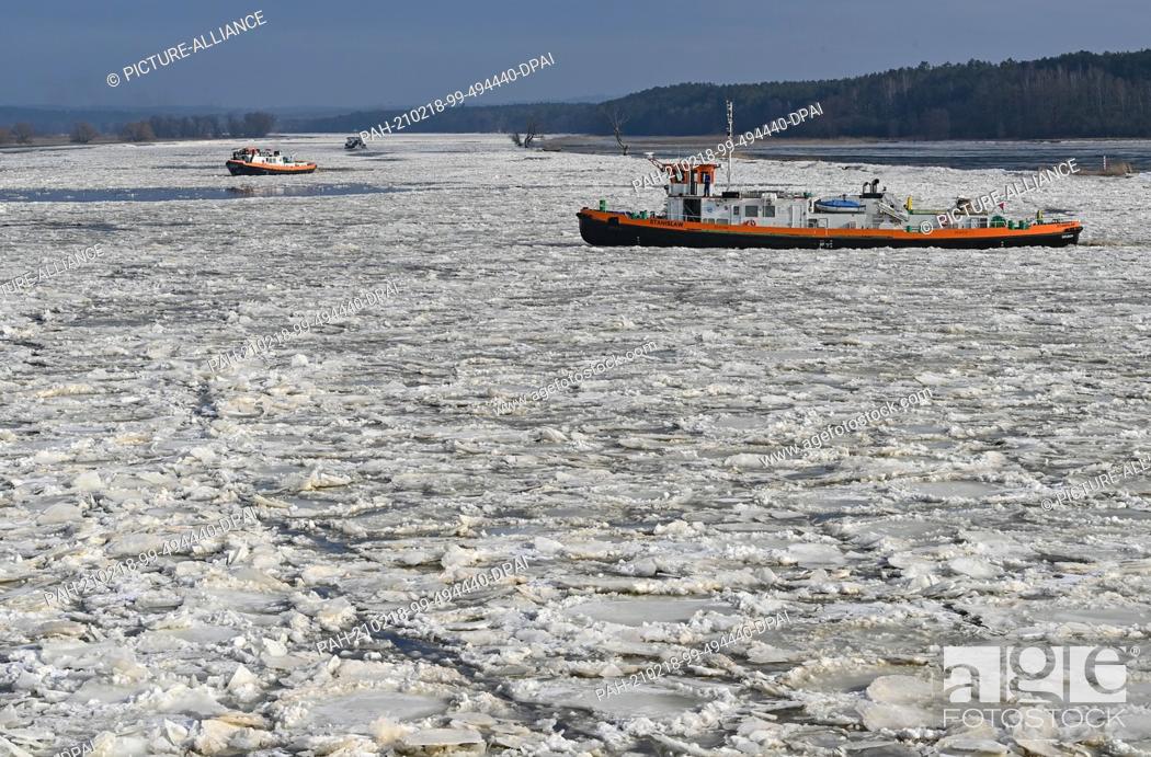 Stock Photo: 18 February 2021, Brandenburg, Schwedt: Icebreakers navigate on the German-Polish border river Oder. Drift ice is increasing the risk of flooding in some.