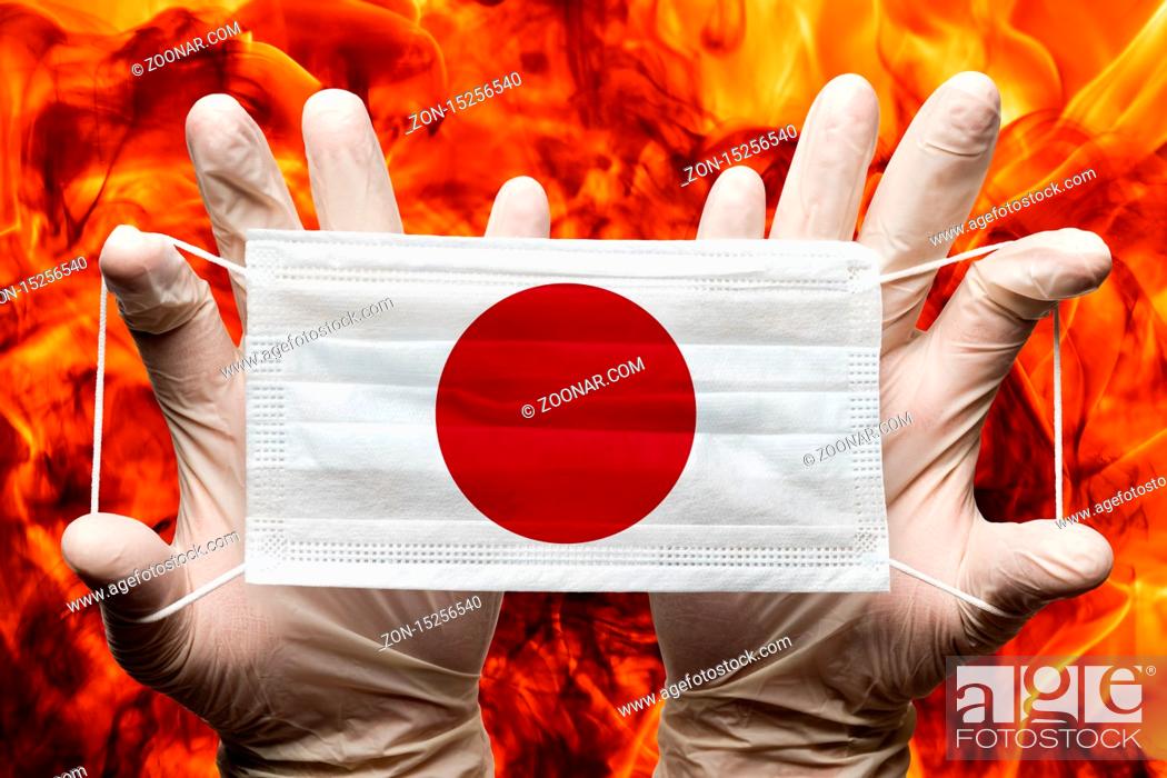 Stock Photo: Doctor holding in white gloves protection medical face mask, respiratory bandage with Japan national country flag superimposed on mask.