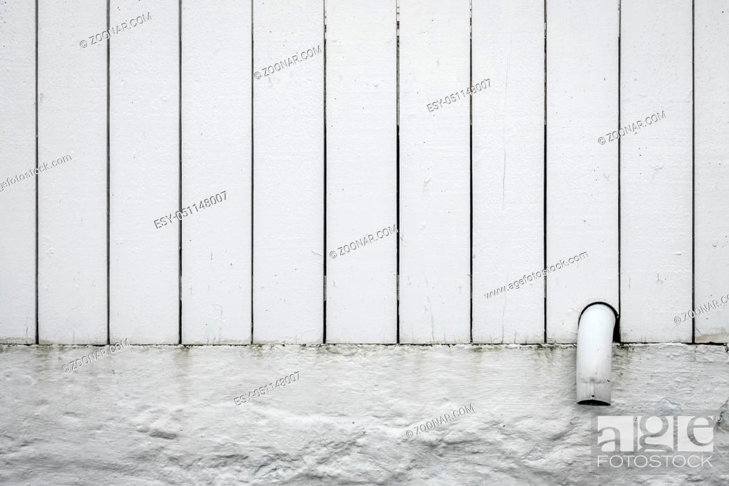 Stock Photo: Detail of a small pipe tip sticking out of a white wooden fence.