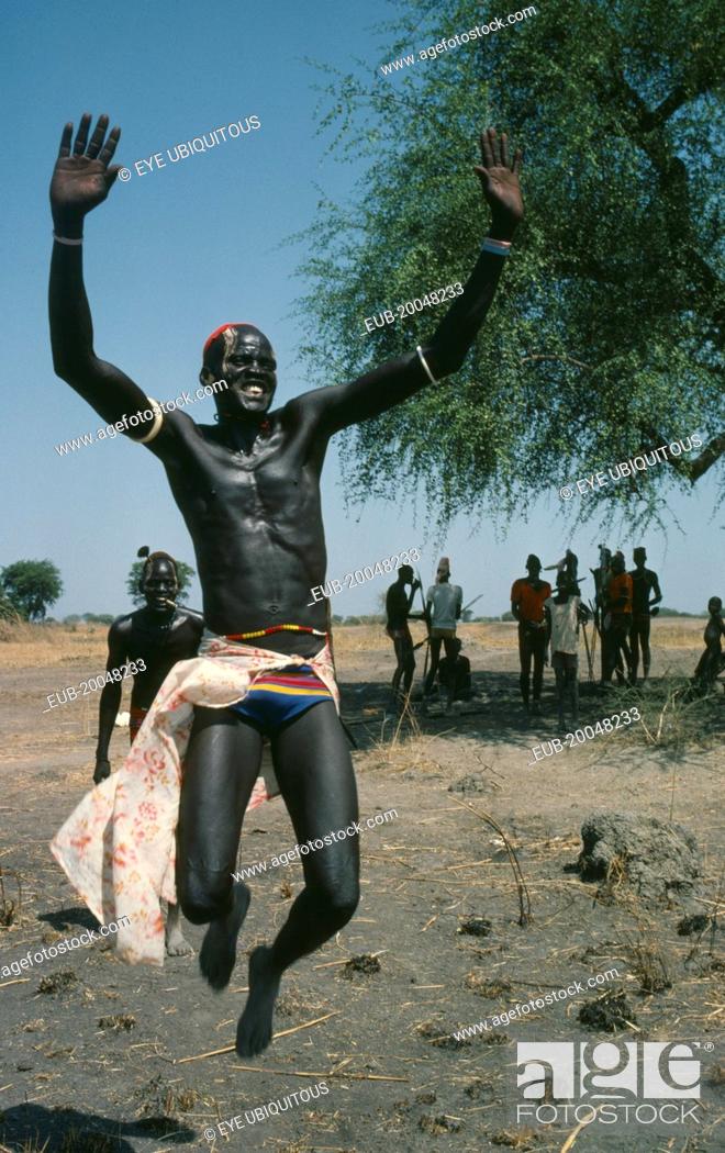Stock Photo: Dinka tribesman leaping into air.