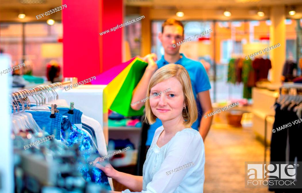 Stock Photo: young couple in the clothes shop looking for a new dress.