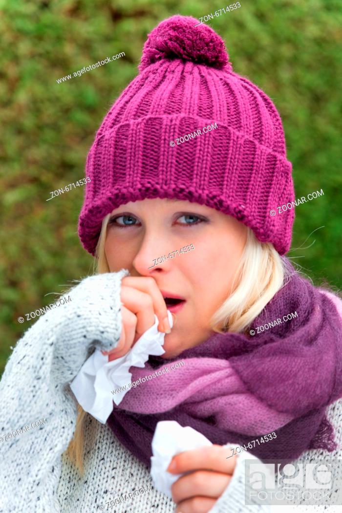 Stock Photo: Eine junge Frau hat Schnupfen und ist erkältet. Herbstzeit ist Zeit für Grippe, Schnupfen und Erkältung.