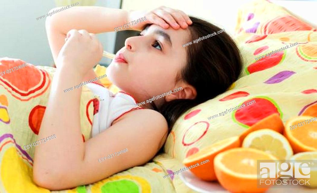 Stock Photo: Little girl with a thermometer in bed.
