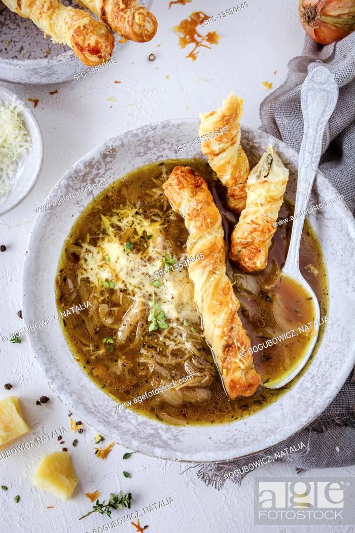 Stock Photo: French onion soup with Parmesan cheese and puff pastry fingers.