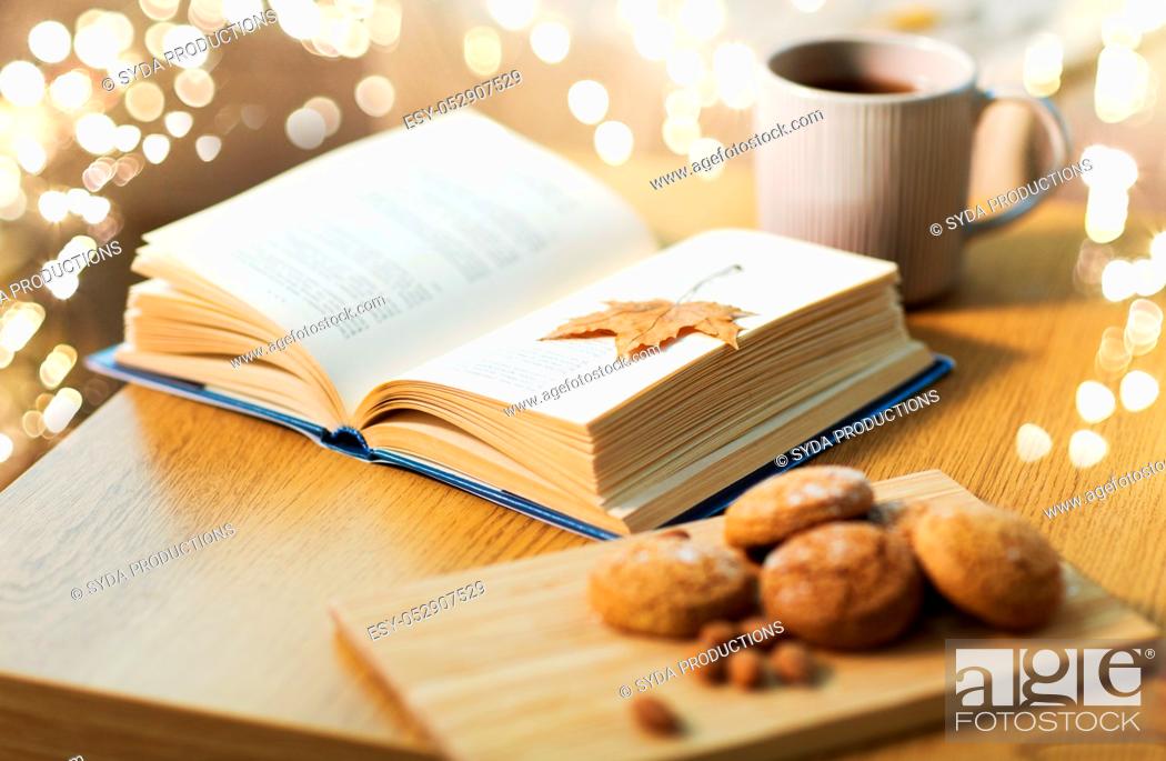 Stock Photo: book with autumn leaf, cookies and tea on table.