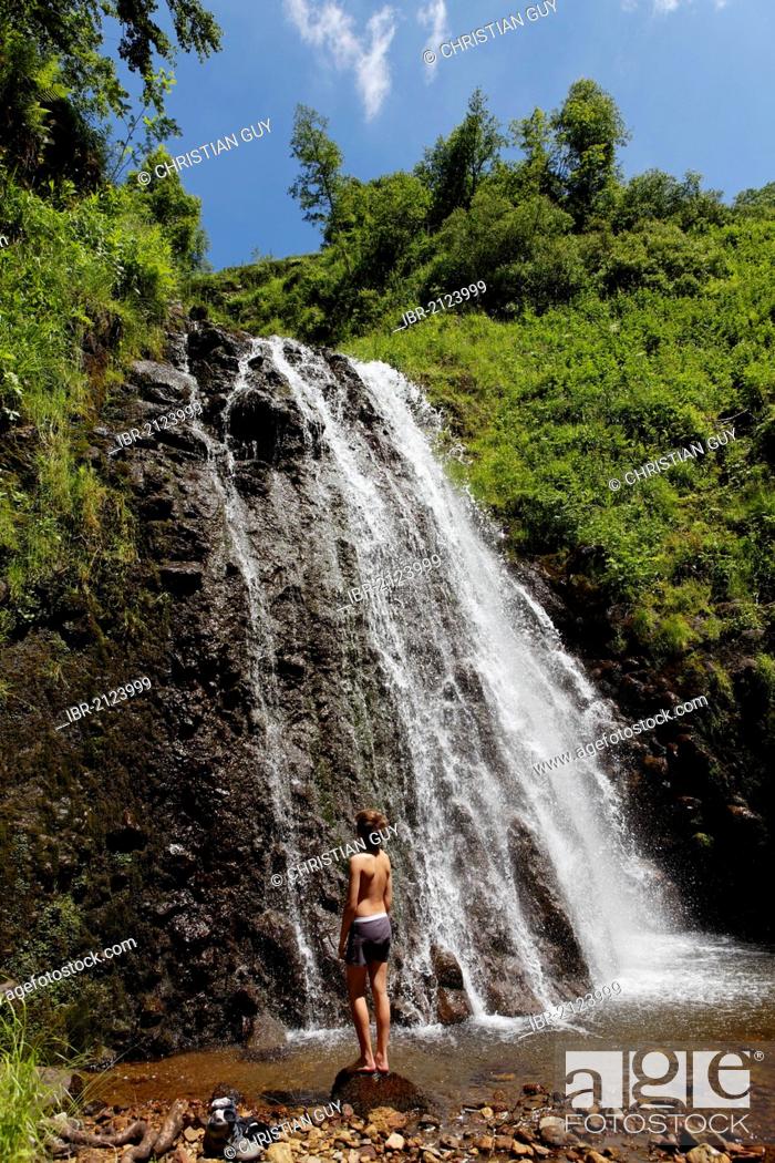 Stock Photo: Young man at waterfall, Fontaine Salee reserve, Auvergne Volcanoes Regional Nature Park, massif of Sancy, Puy de Dome, France, Europe.
