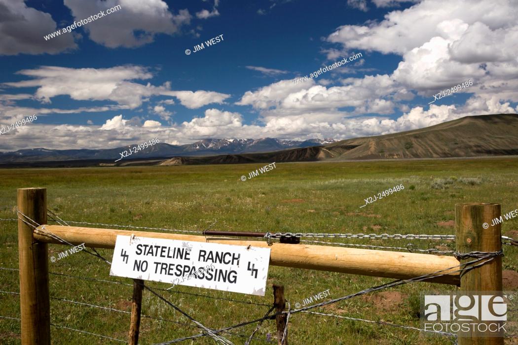Stock Photo: Cowdrey, Colorado - A ""no trespassing"" sign on the Stateline Ranch prohibits entry onto ranch land. The Sierra Madre mountain range and the continental divide.