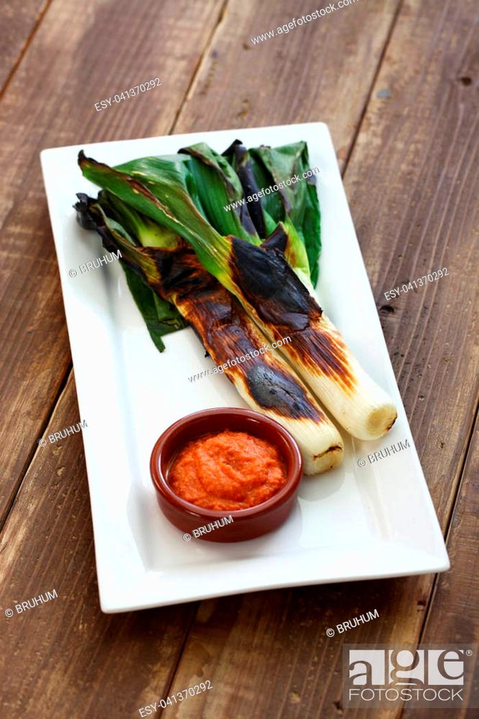 Stock Photo: roasted calcots with romesco sauce for dipping, spanish catalan cuisine.