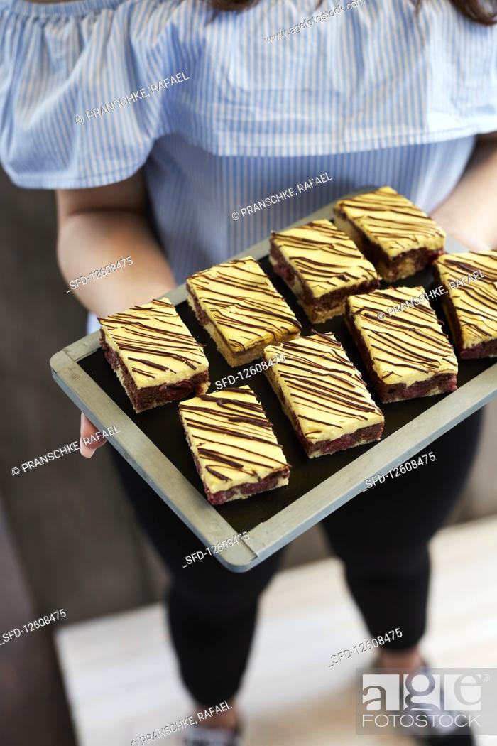 Stock Photo: A woman serving donauwellen on a tray.