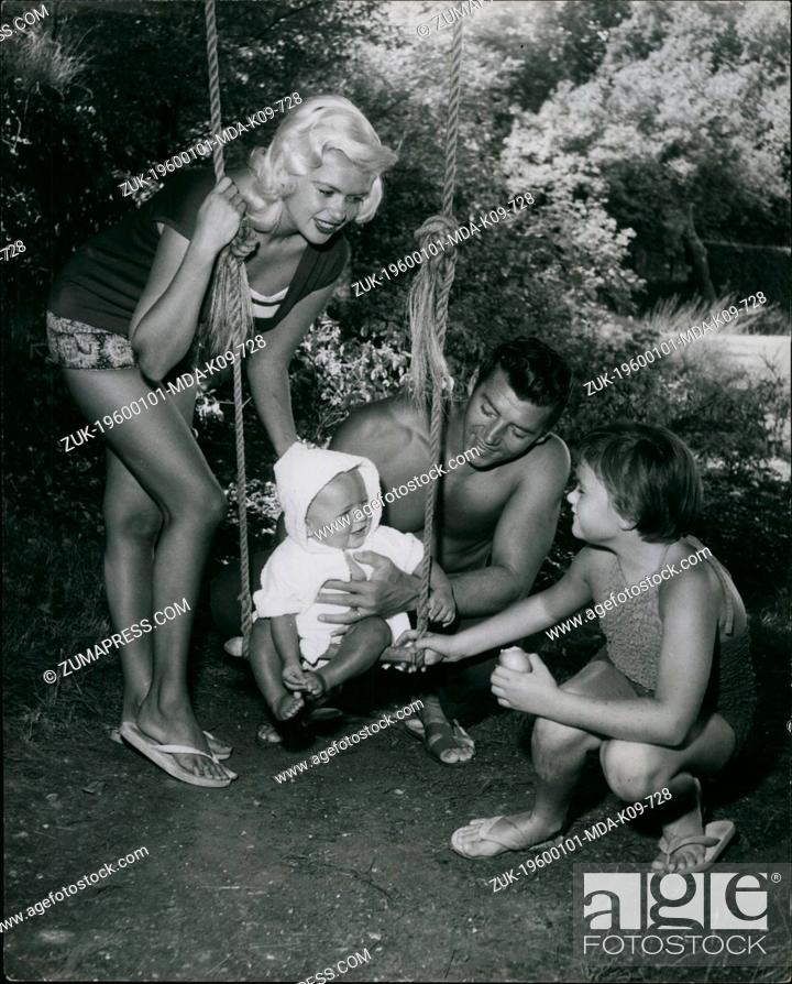 Stock Photo: Jan 1, 1960 - On the swing, Baby Mikos gets encouragement from the whole family as he prepares to embark on his first swing.