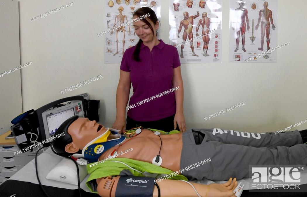 Stock Photo: 05 July 2019, Schleswig-Holstein, Langeneß: Community nurse Astrid Hansen demonstrates in practice on the Hallig Langeness with a dummy the work with an.