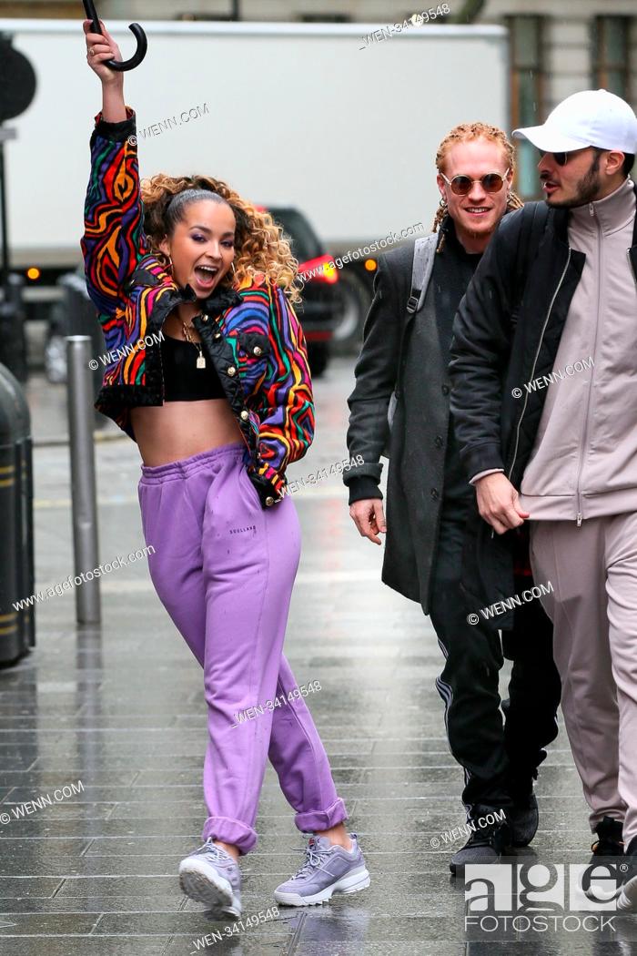 Stock Photo: Singer Ella Eyre and Banx & Ranx arriving at Global Radio Studios in the heavy rain. Ella had a matching purple umbrella to go with her trousers and was.