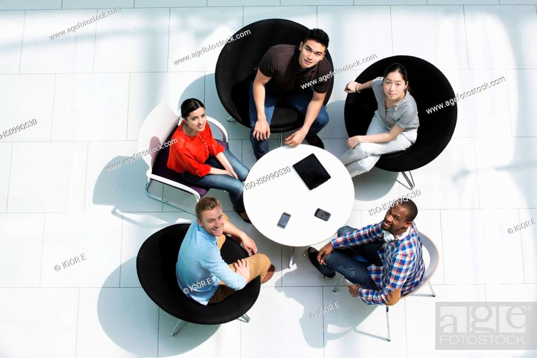 Stock Photo: Overhead view of colleagues in meeting, looking up at camera.