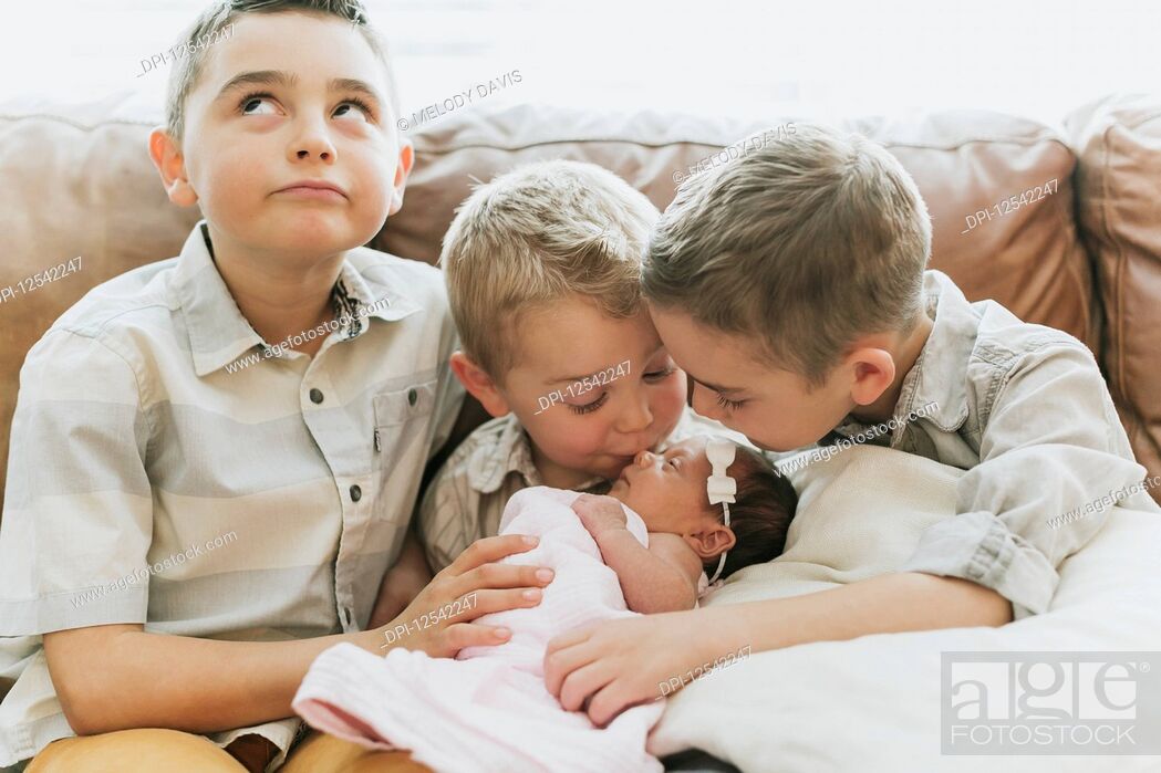 Stock Photo: Three young boys with their newborn baby sister; Surrey, British Columbia, Canada.