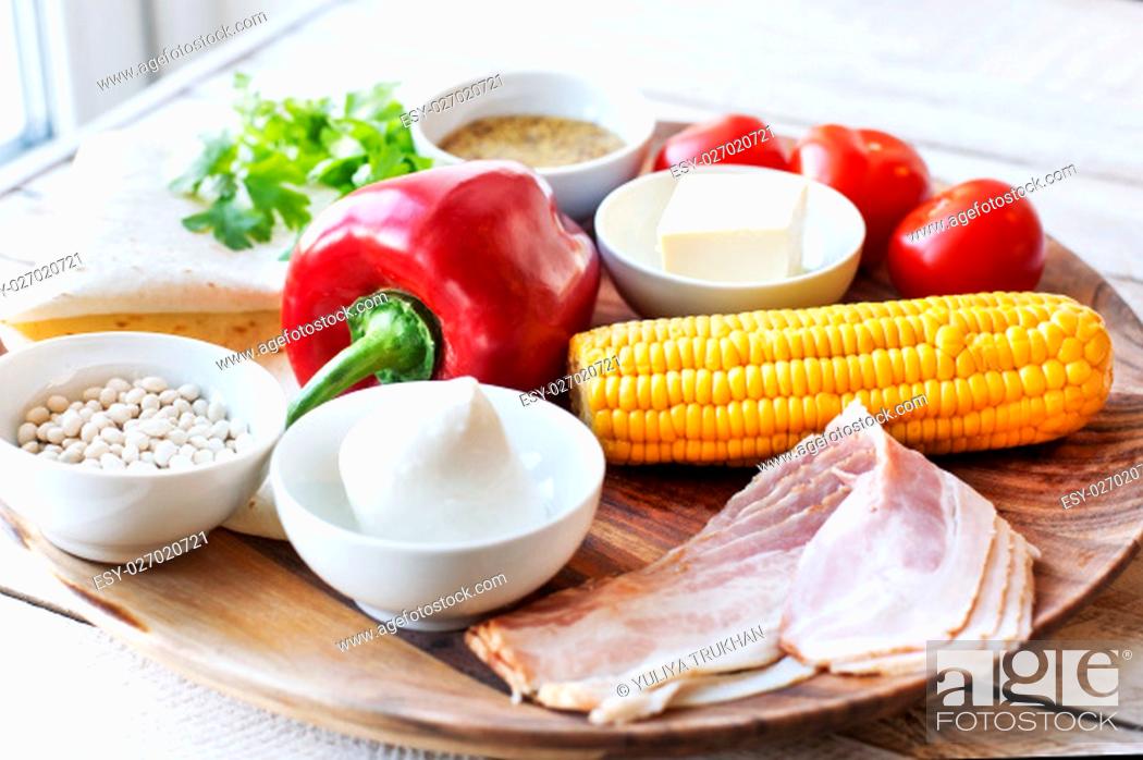 Stock Photo: Ingredients for cooking Mexican Quesadilla wrap with vegetables, corn, sweet pepper and sauces on the parchment and table. horizontal view.