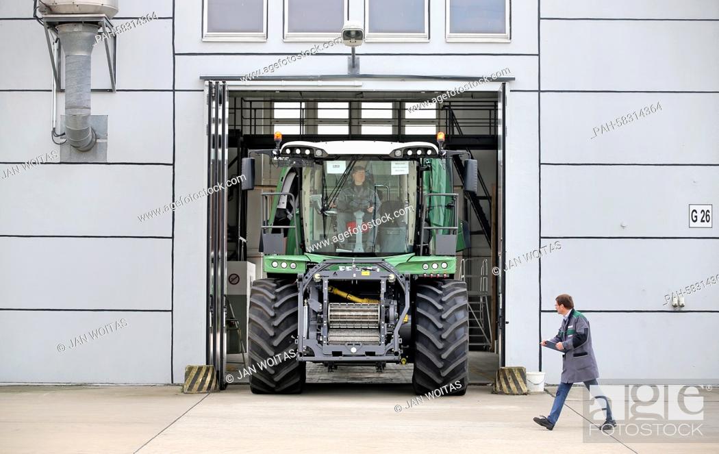 Stock Photo: Two employees do the quality check of a Fendt Katana 65 corn chopper in front of a former tank maintenance hall in Hohenmoelsen, Germany, 17 April 2015.