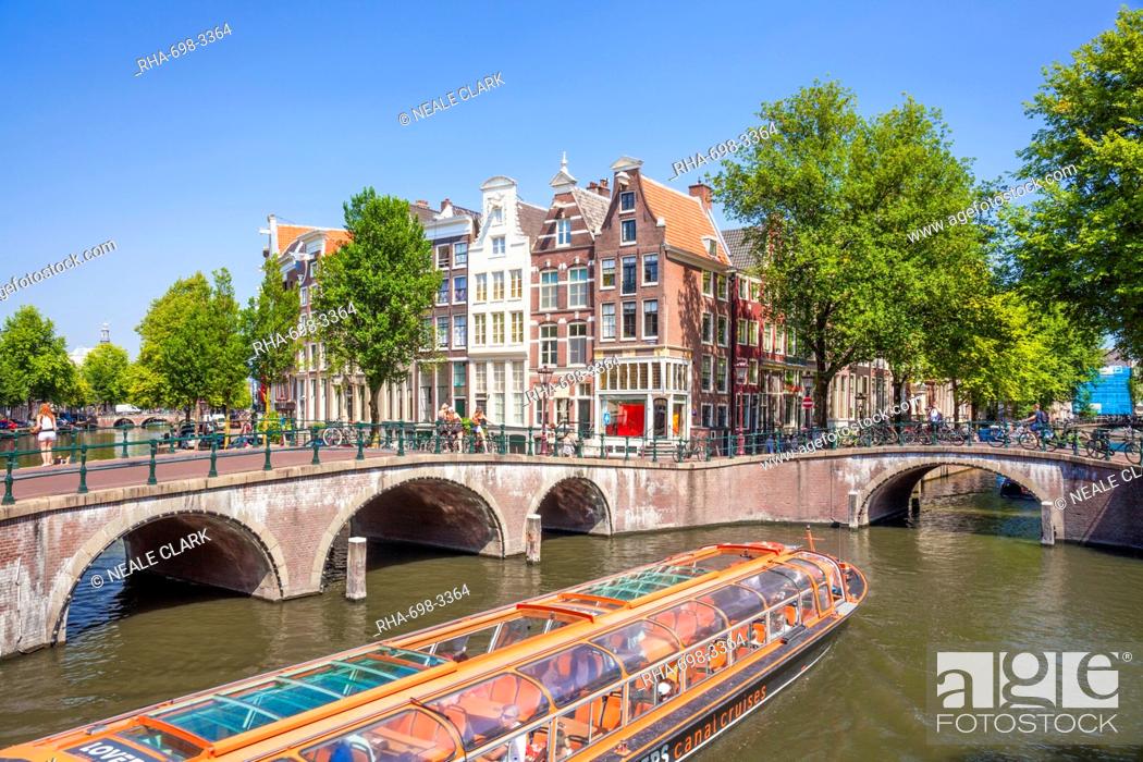 Stock Photo: Canal tour boat and bridges at the junction of Leidsegracht Canal and Keizergracht Canal, Amsterdam, North Holland, Netherlands, Europe.