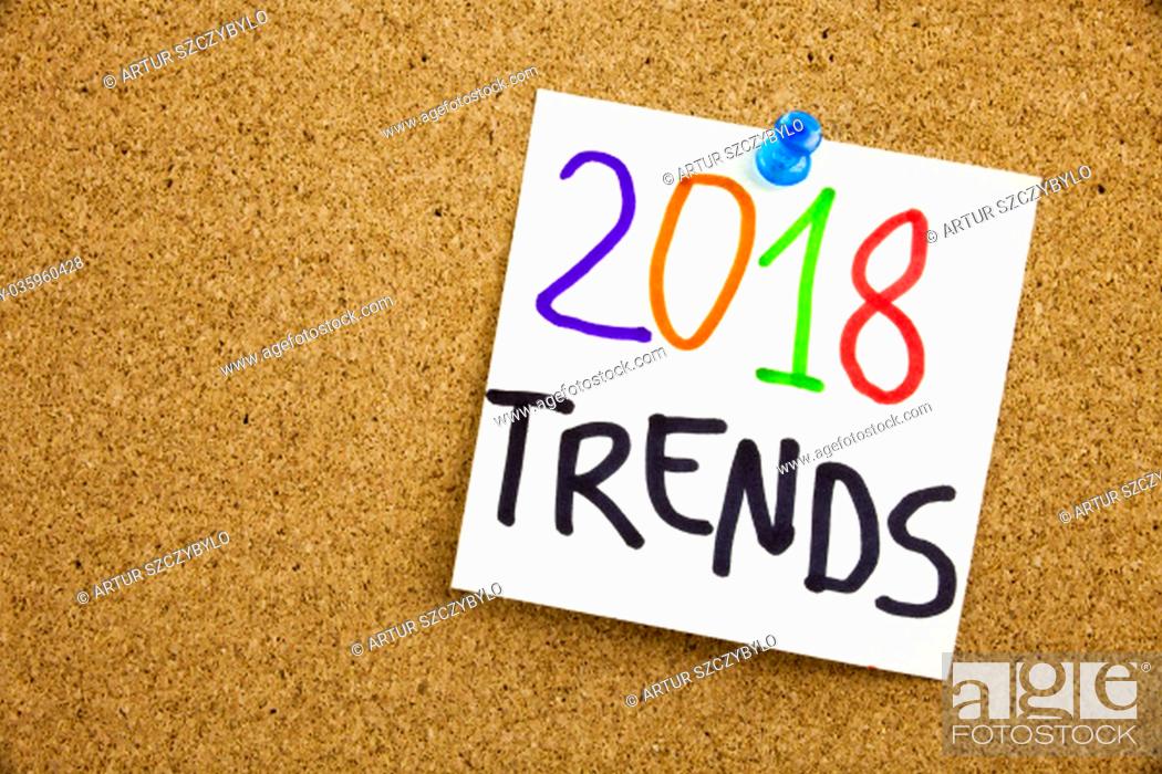 Stock Photo: Phrase 2018 TRENDS in black ext on a sticky note pinned to a cork notice board.