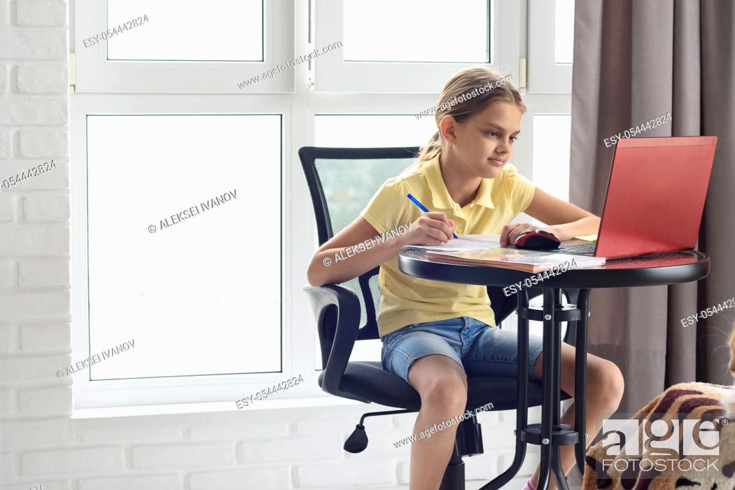 Stock Photo: Girl studying remotely online while at home.