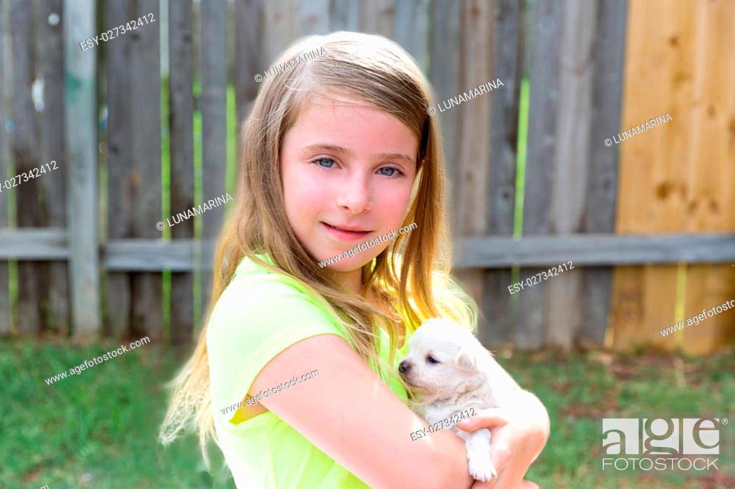 Stock Photo: Blond kid girl with puppy pet chihuahua playing happy with doggy outdoor.