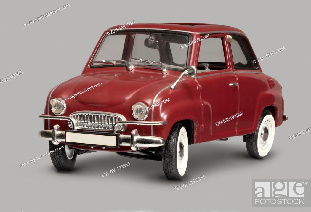 Stock Photo: model of a historic red microcar in grey back.