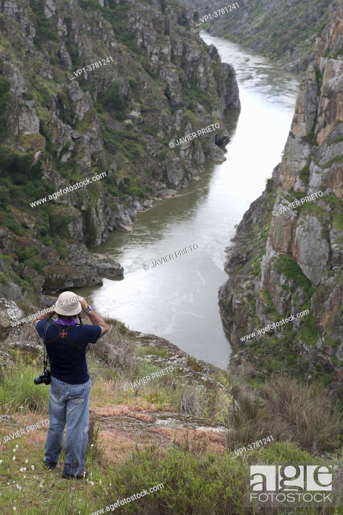 Stock Photo: A hiker observes the landscape with binoculars from the Riscos de La Finiestra, on the Sendero de la Retanja y la Finiestra.