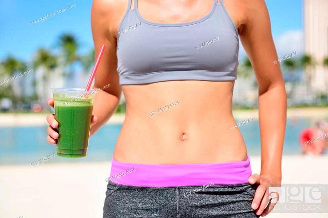 Stock Photo: Healthy lifestyle fitness woman drinking green vegetable smoothie juice after running exercise. Close up of smoothie and stomach.