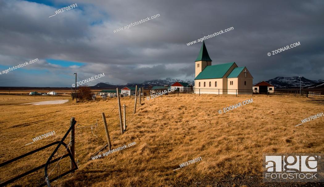 Stock Photo: Traditional Icelandic church with green roof  reflected on a frozen lake at Snaefellsnes Peninsula in Iceland.