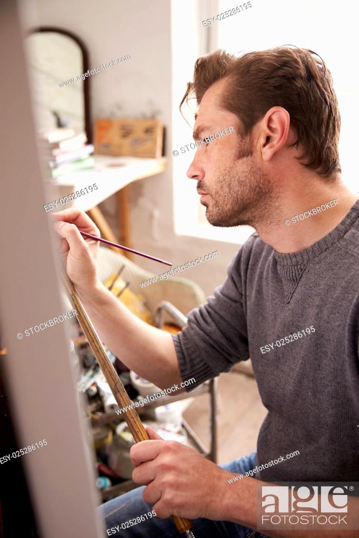 Stock Photo: Male Artist Working On Painting In Studio.