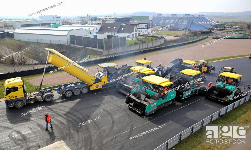 Stock Photo: Workers use special machinery to renew the asphalt surface of the Sachsenring racing circuit in Hohenstein-Ernstthal, Germany.