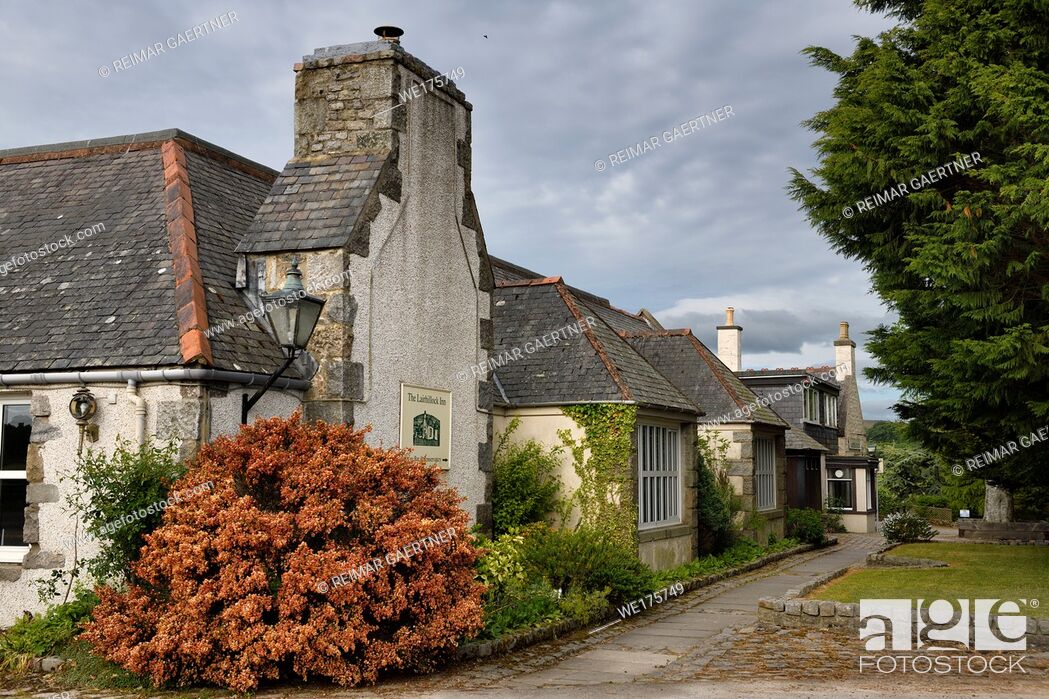 Stock Photo: The Lairhillock Inn classic Scottish Inn near Aberdeen Scotland UK with red Lena Scotch broom bush in June.