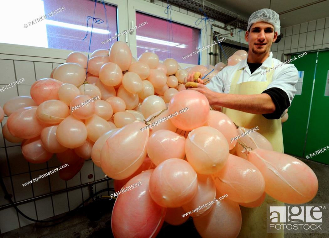 Stock Photo: Butcher Timo Troescher from butcher's shop Winterhalter hangs up pig bladders filled up with air so they will dry in Elzach, Germany, 9 January 2013.