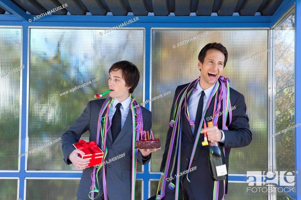 Stock Photo: businessmen at bus stop, with party set.
