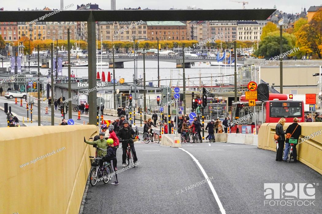 Stock Photo: Stockholm, Sweden Bicyclists riding the new Slussbron, or Golden Bridge, at Slussen, inaugurated Oct 25, 2020.