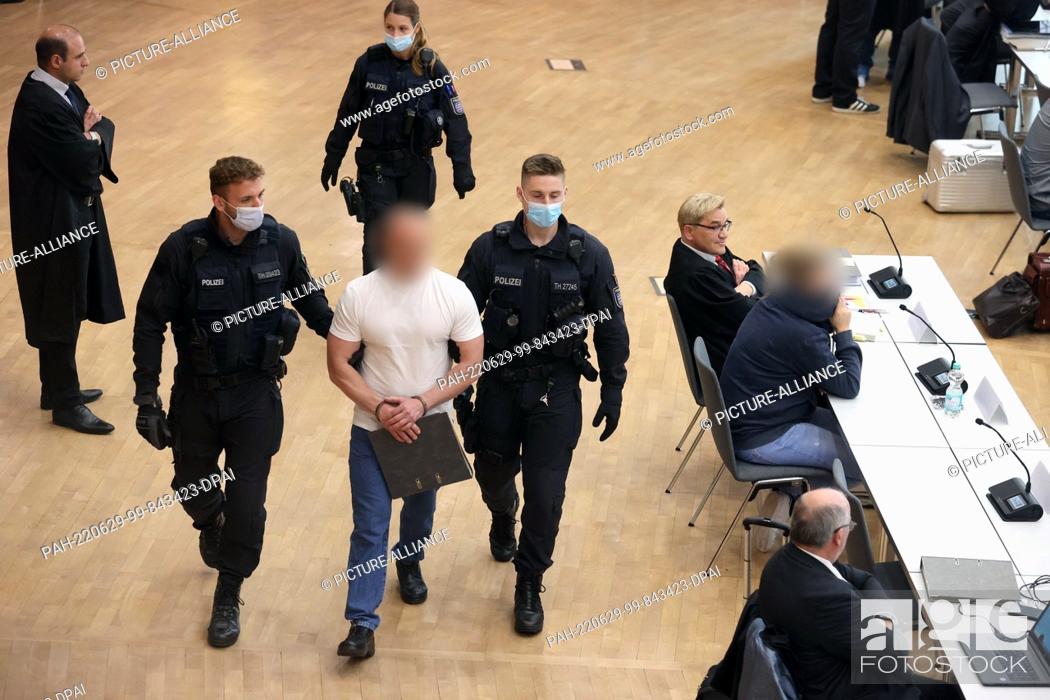 Imagen: 29 June 2022, Thuringia, Erfurt: A defendant (M) is led into the hearing room of the Congress Center of the Messe for a trial on drug trafficking of a gang in.