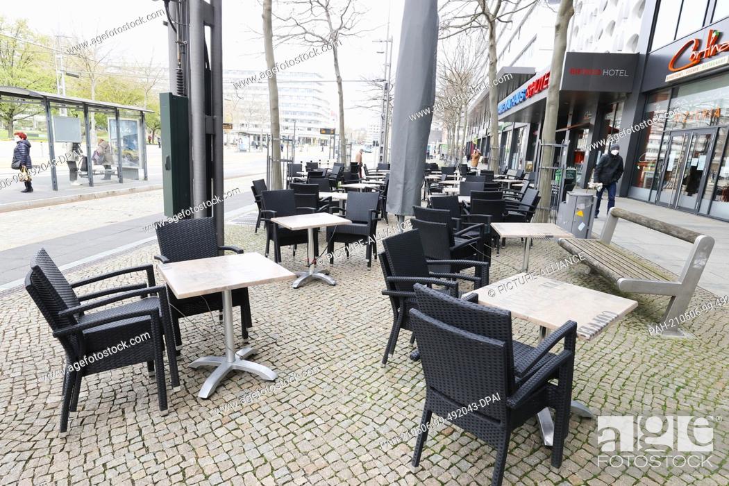 Stock Photo: 06 May 2021, Saxony, Chemnitz: Empty tables and chairs are lined up outside a downtown restaurant. The 7-day incidence is still over 200 in the city.