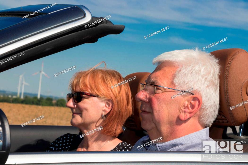 Stock Photo: Older couple drives with a luxury convertible car on a sunny day.