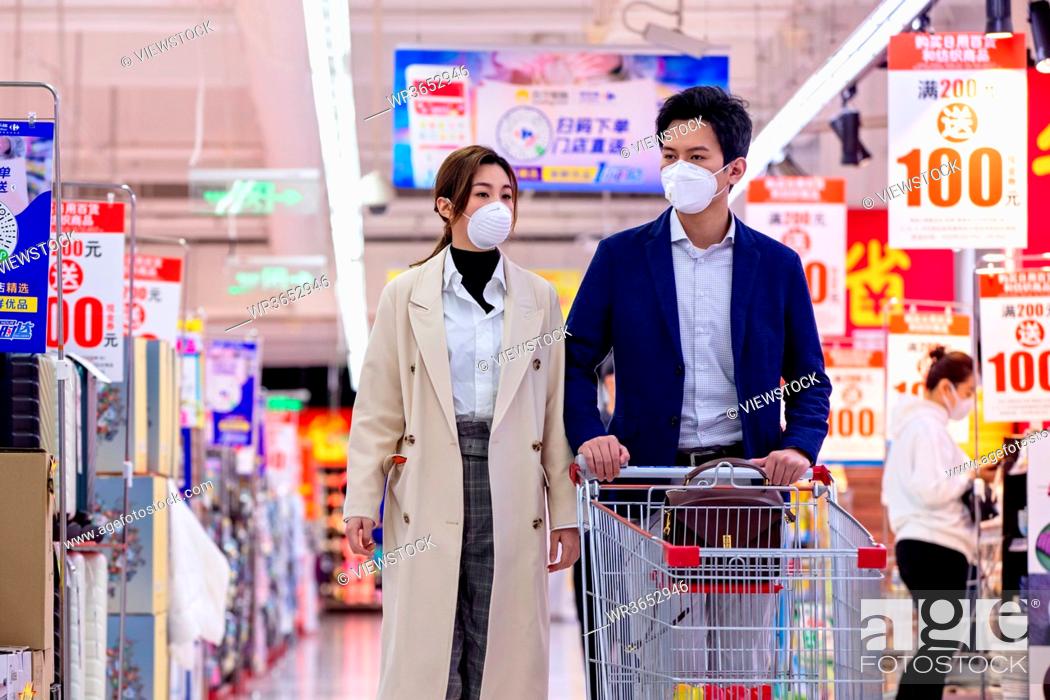 Stock Photo: Young couples shopping in the supermarket.