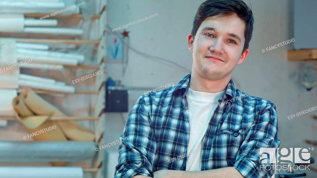Stock Photo: Cheerful young workre in a frame atelier workshop smiling and looking at camera. Close up. Professional shot in 4K resolution. 083. You can use it e.