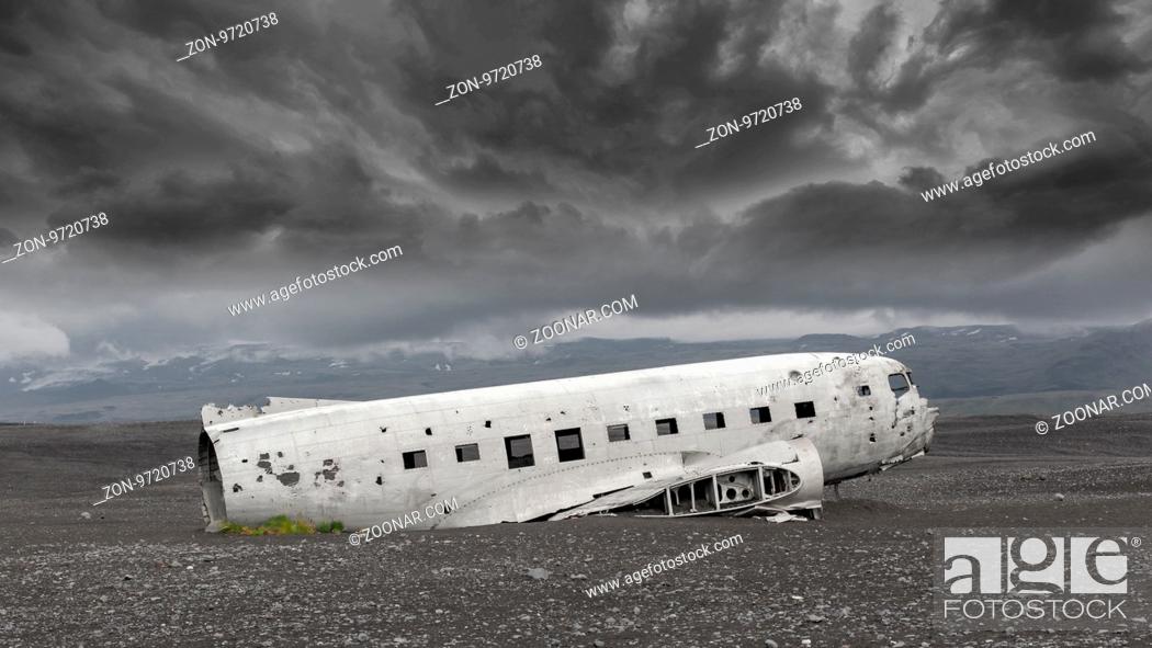Stock Photo: The abandoned wreck of a US military plane on Solheimasandur beach near Vik, Southern Iceland - Stormy clouds.