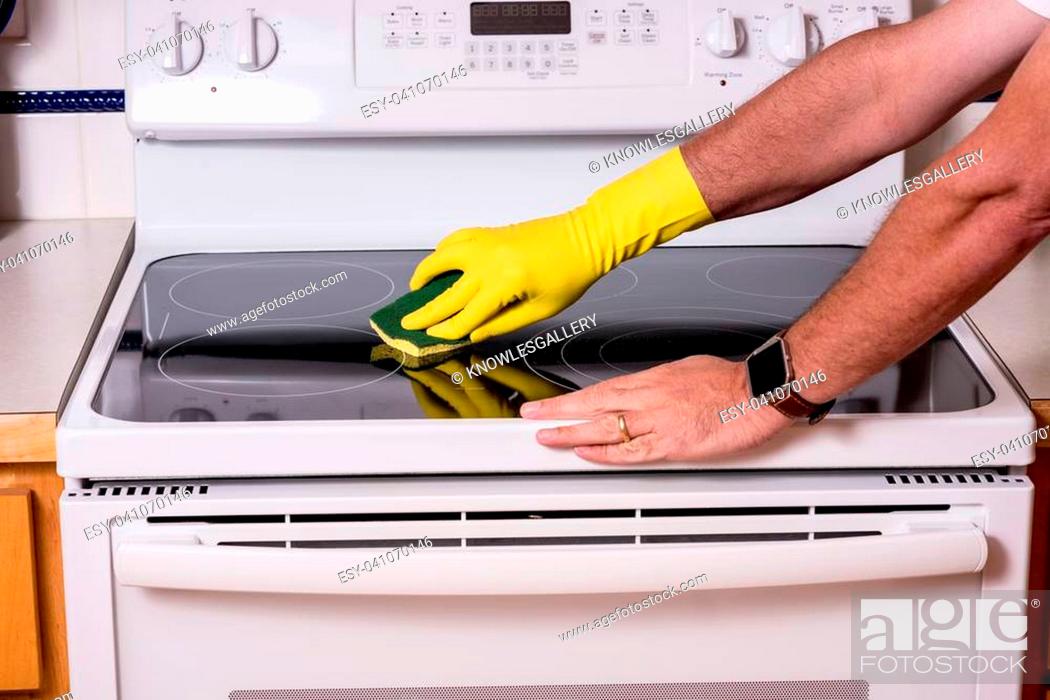 Stock Photo: Cleaning a top of a oven range to clean it.