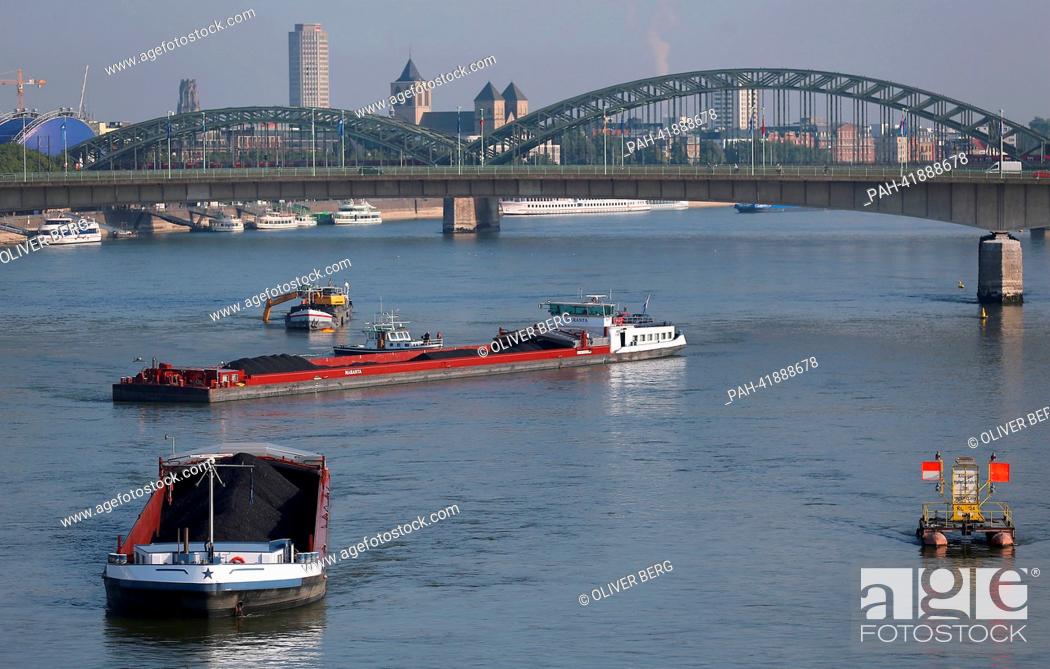 Stock Photo: A dredger digs gravel out of the the Rhine in Cologne, Germany, 20 August 2013. A combined push boat and barge lie in front of the dredger.