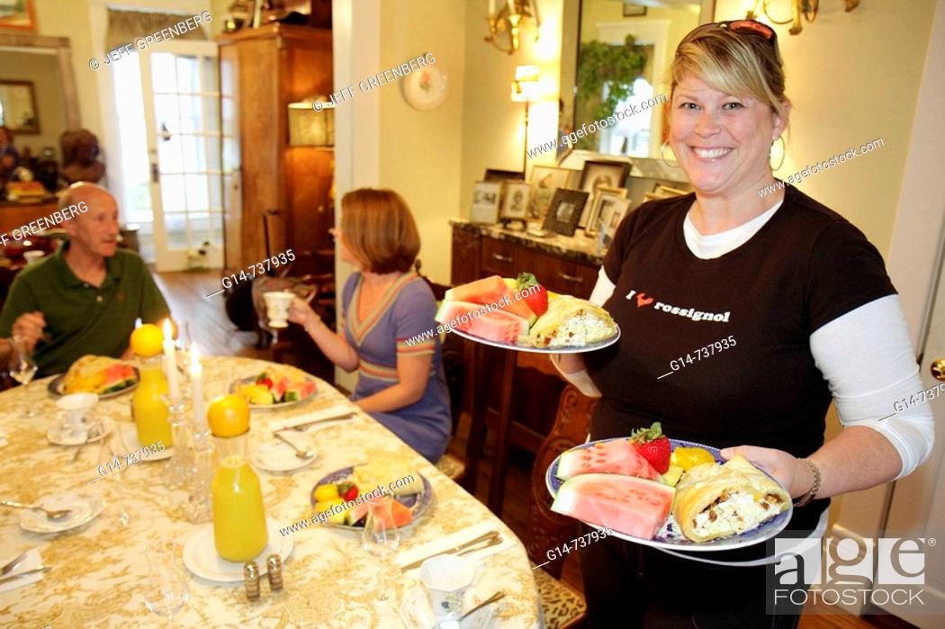 Stock Photo: Arkansas, Eureka Springs, Mount Victoria Bed and Breakfast Inn, woman, owner, serves, food, fruit, watermelon, guests, table, service, hospitality,.