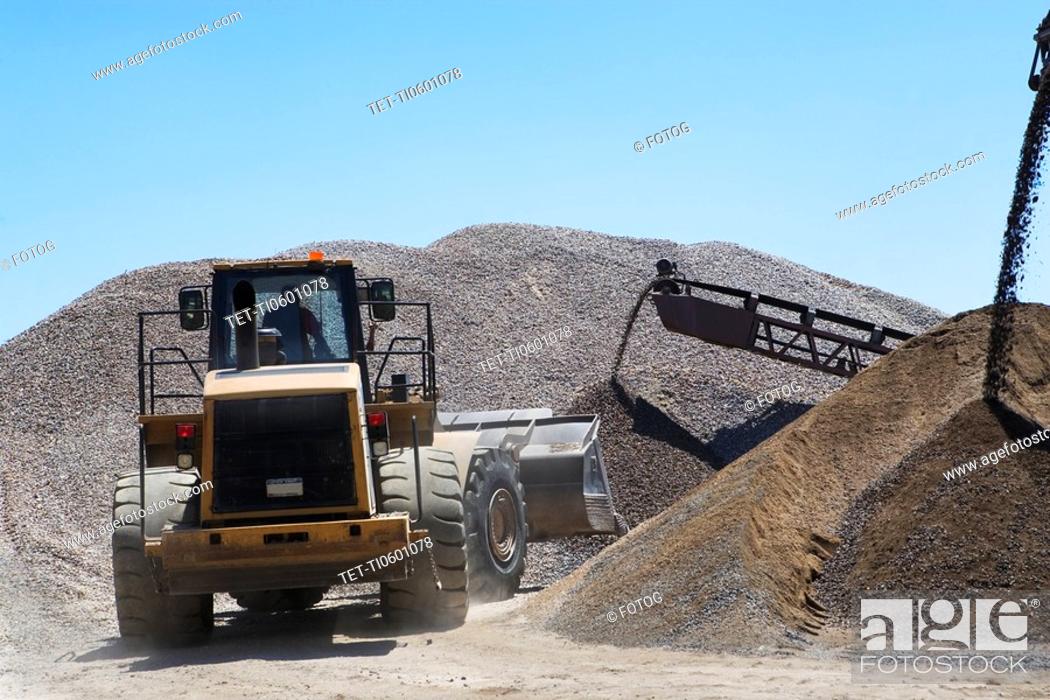 Stock Photo: Bucket loader moving pile of gravel.