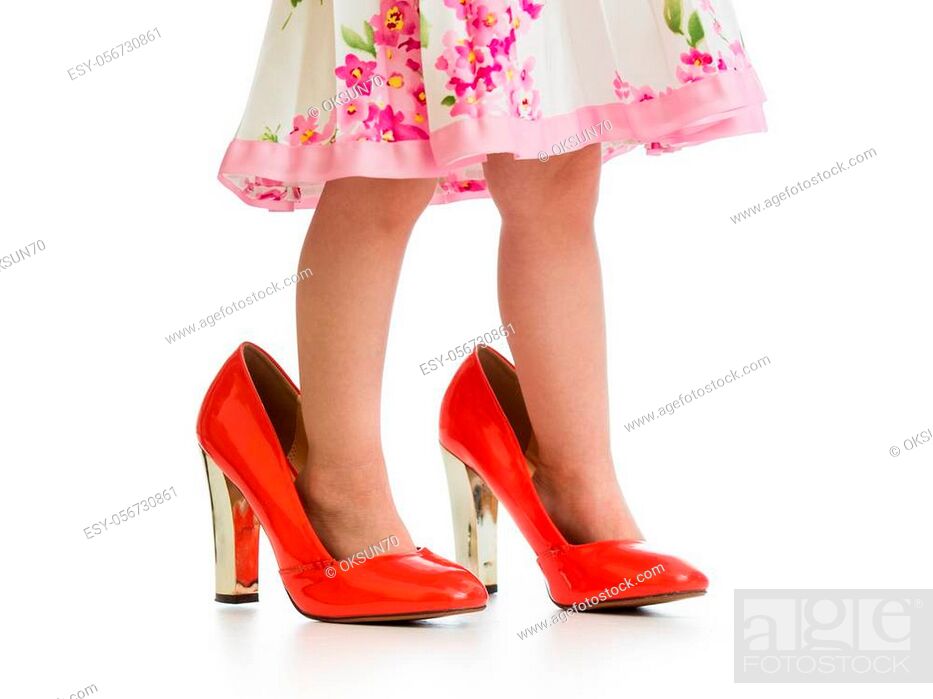 Stock Photo: child girl trying mother's shoes on her feet isolated.